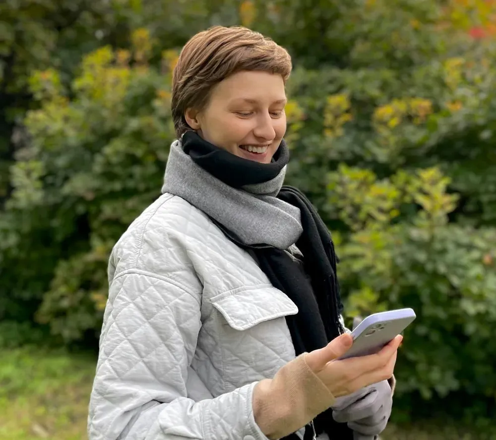 Student reflecting with phone against open sky