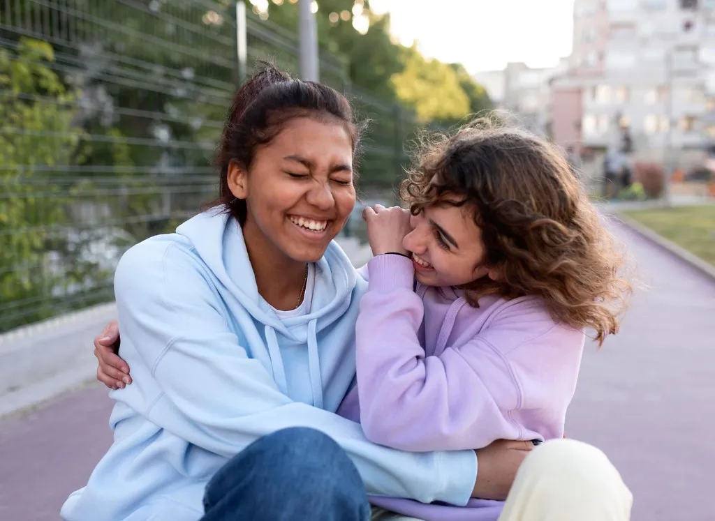 Two students laughing together outdoors